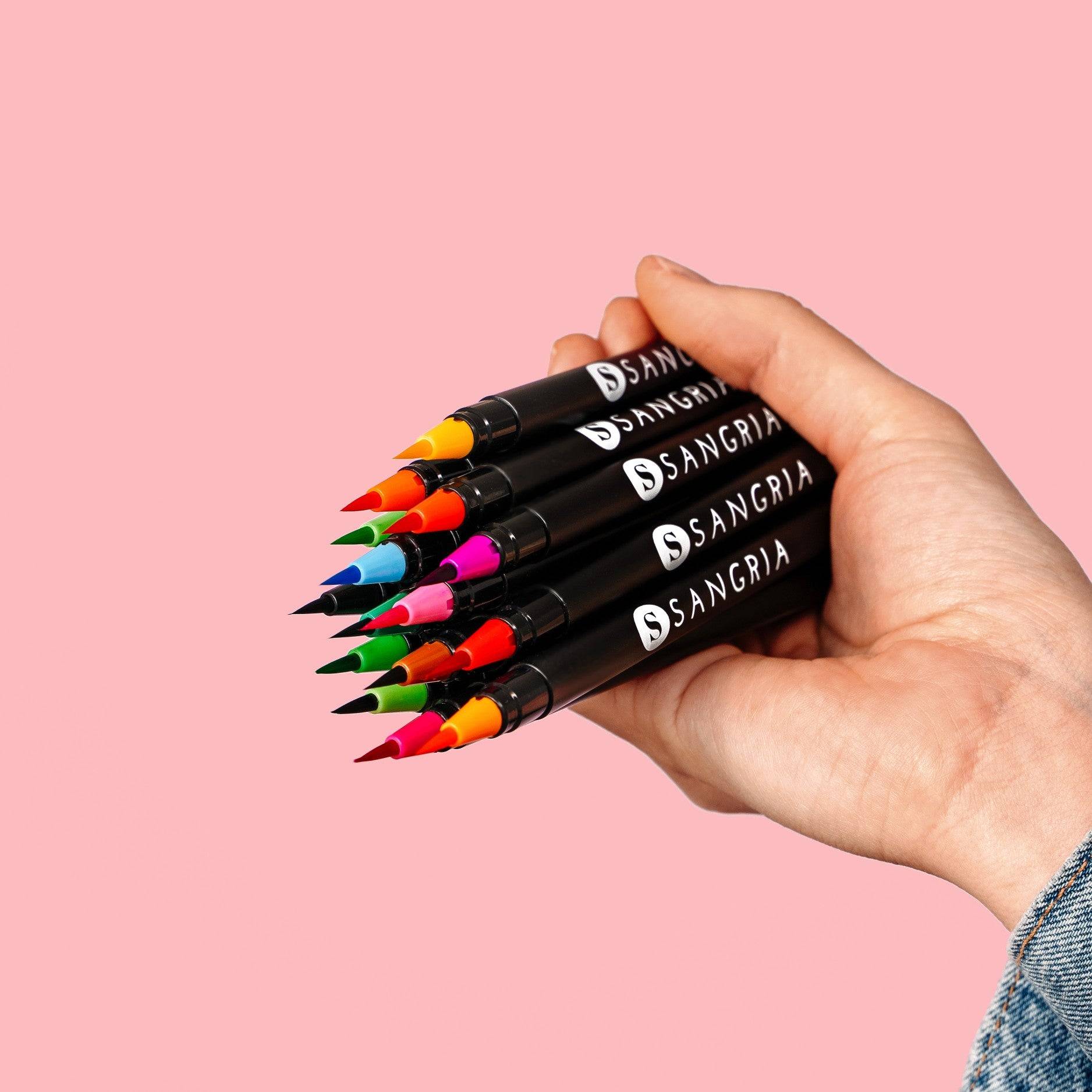 a person holding a bunch of markers in their hand